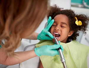 a child having her teeth cleaned at the dentist’s office