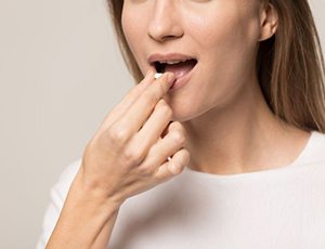Woman preparing to swallow pill for oral conscious sedation