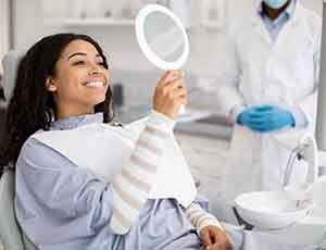 a woman looking into a mirror at a dental office